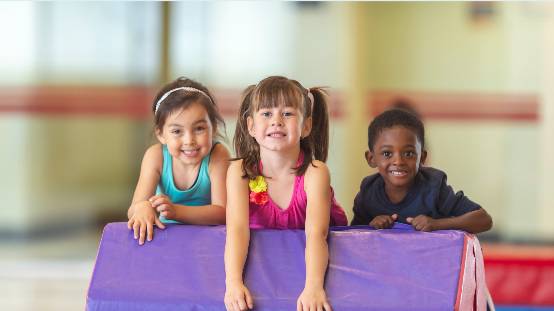 image of three preschool gymnasts on a block